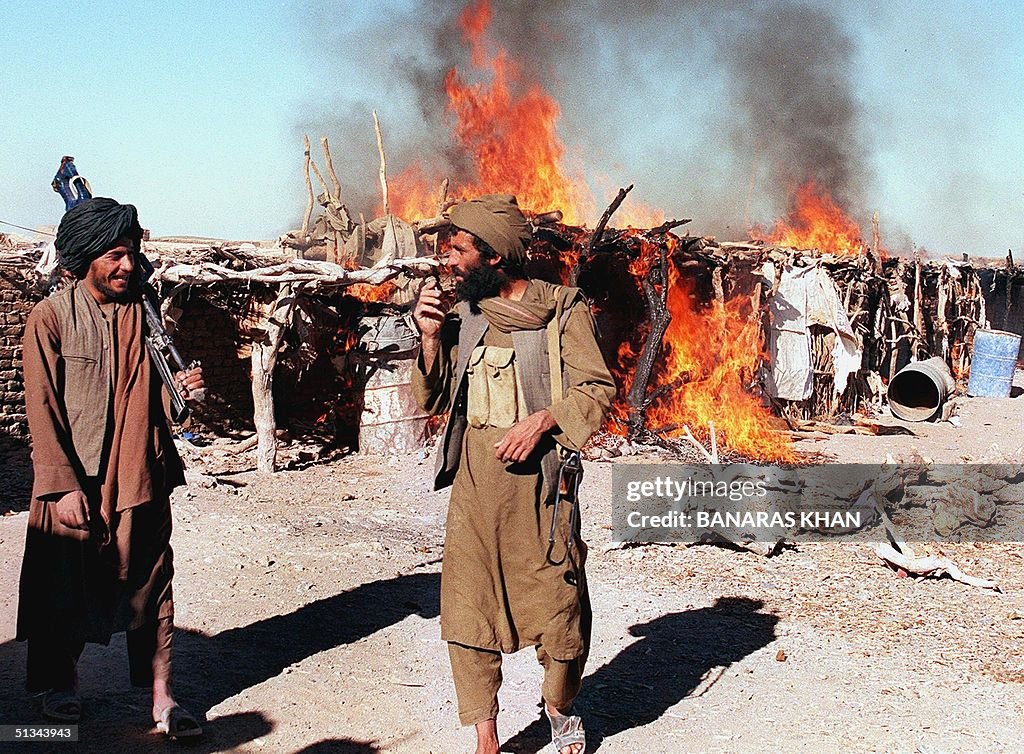 Taliban soldiers stand guard as a heroin making fa