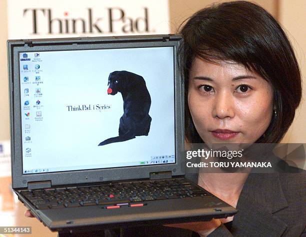An employee of IBM Japan, Ltd. Shows its new laptop computer "ThinkPad i Series 1620" in Tokyo, 29 August 2000. The firm will put the new personal...