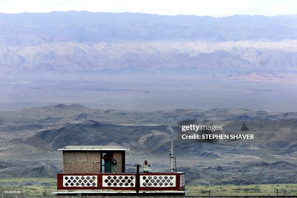 A lone border patrol officer peers through his bin