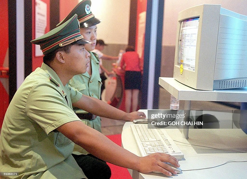 Chinese policemen surf the Internet at a computer