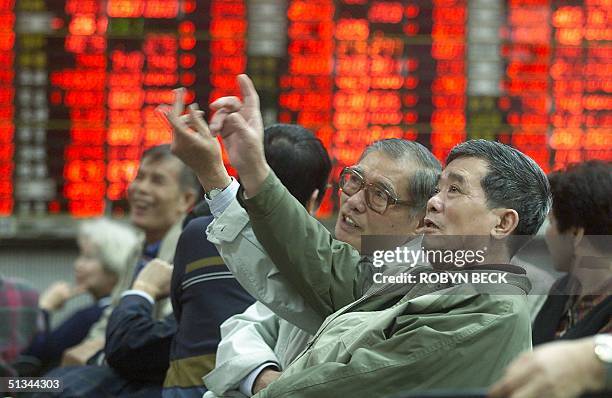 Investors gesture while monitoring share prices at a brokerage office in Taipei 21 March 2000. Taiwan's benchmark stock index climbed 5.5 percent to...