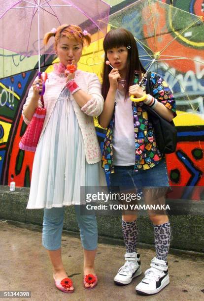 Eighteen-year-old student Yoko Sasaki and her classmate Anna Shimasaki pose for pictures on a street at Tokyo fashion district Harajuku, 17 June...