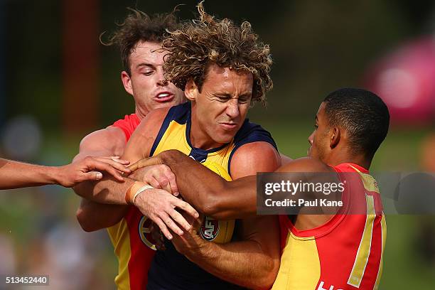 Matt Priddis of the Eagles gets tackled by Luke Russell and Touk Miller of the Suns during the 2016 AFL NAB Challenge match between the West Coast...