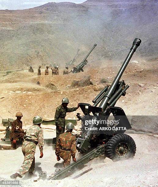 Soldiers from the Indian army fire their 105mm guns, 31 May 1999, from their outpost near Kargil towards the India-Pakistan border in Kashmir. India...