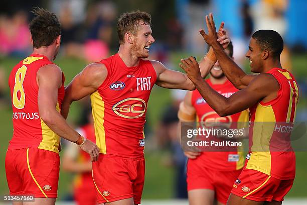 Ryan Davis of the Suns celebrates a goal with team mates during the 2016 AFL NAB Challenge match between the West Coast Eagles and the Gold Coast...