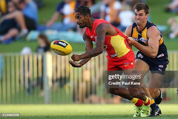 Jarrod Garlett of the Suns handballs against Jamie Cripps of the Eagles during the 2016 AFL NAB Challenge match between the West Coast Eagles and the...