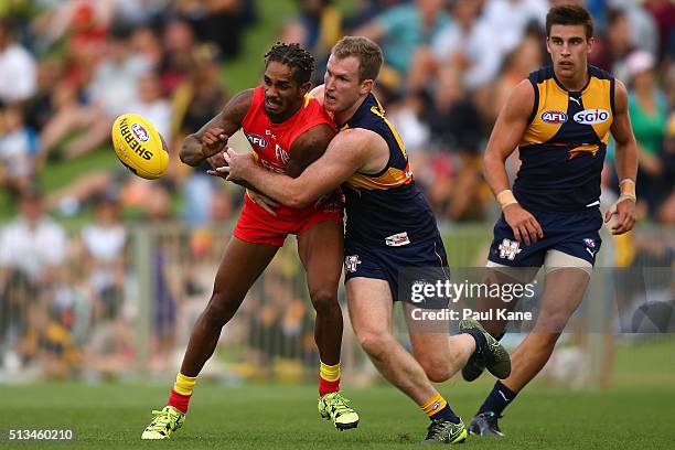 Jarrod Garlett of the Suns handballs against Xavier Ellis of the Eagles during the 2016 AFL NAB Challenge match between the West Coast Eagles and the...