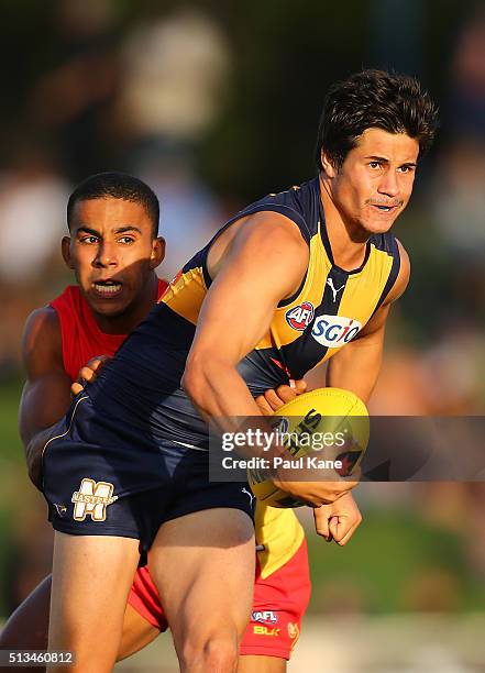 Liam Duggan of the Eagles looks to handball while being tackled by Touk Miller of the Suns during the 2016 AFL NAB Challenge match between the West...