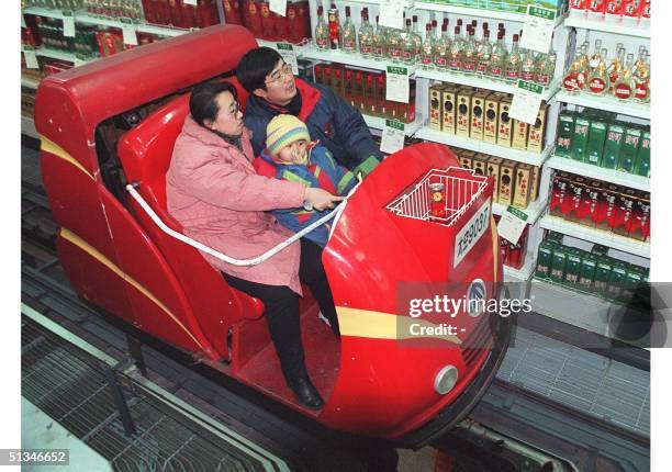 Shoppers in the northeastern Chinese city of Shenyang go about their shopping on a new electric cart at a supermarket18 January. This latest...