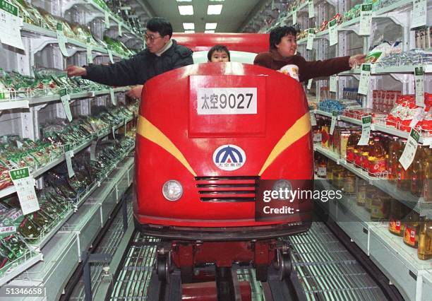 Shoppers in the northeastern Chinese city of Shenyang go about their shopping on a new electric cart at a supermarket 18 January. This latest...