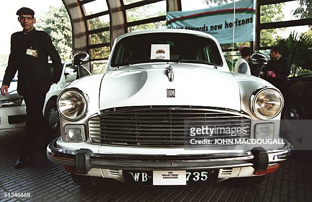 Hotel security guard keeps an eye on a new bullet-proof version of India's trademark car the "Ambassador" during a presentation by leading Indian car...