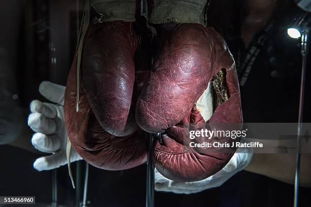 Curator handles the Ali 'split glove' from the 1963 fight v Henry Cooper when Ali's glove split in the forth round - at the preview of the 'I Am The...