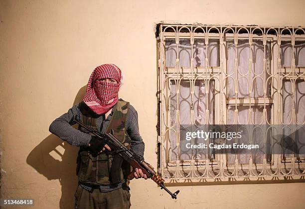 Member of a armed group Patriotic Revolutionary Youth Movement , a youth division of the Kurdistan Workers' Party, PKK, stands guarded as he poses...