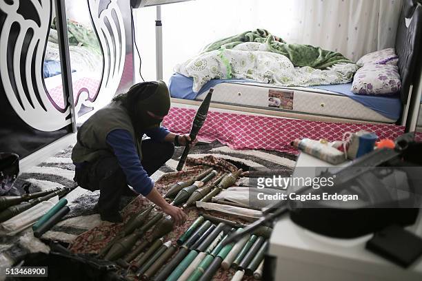Member of the armed group Patriotic Revolutionary Youth Movement , a youth division of the Kurdistan Workers' Party, PKK, prepare his weapons in a...