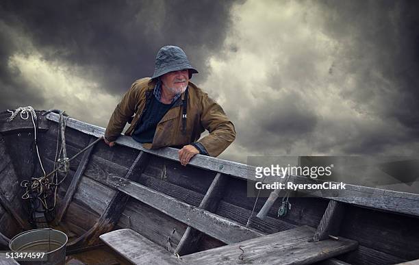 fisherman portrait, stormy sky and dory, nova scotia - waterproof clothing stock pictures, royalty-free photos & images
