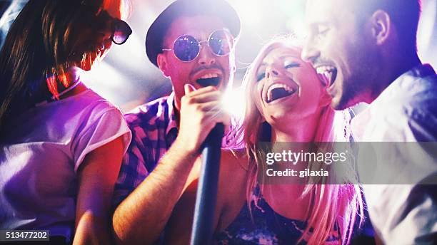 group of people singing karaoke. - singing stockfoto's en -beelden