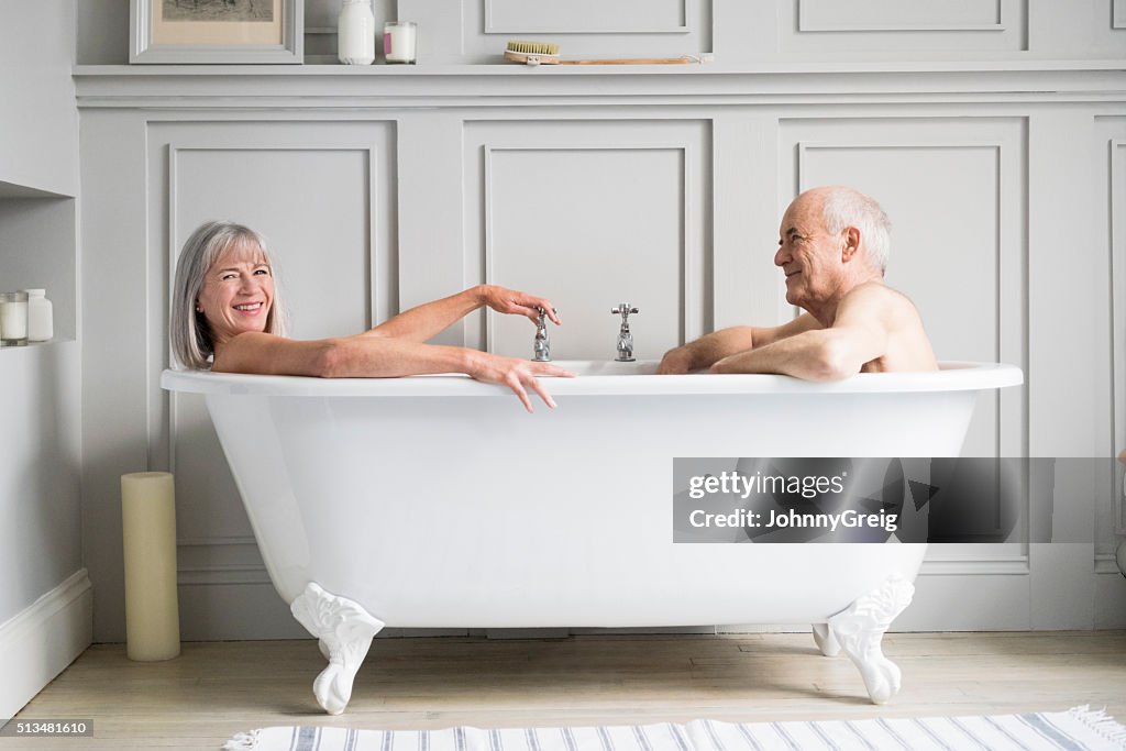 Senior couple in bath together smiling