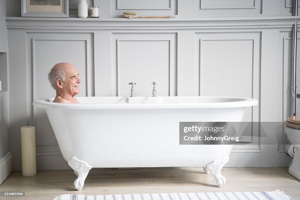 Senior man relaxing in traditional white bath smiling