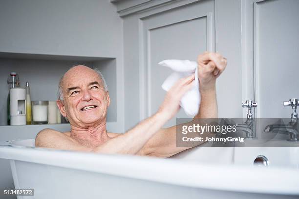 senior man in bath washing himself smiling - taking a bath stock pictures, royalty-free photos & images