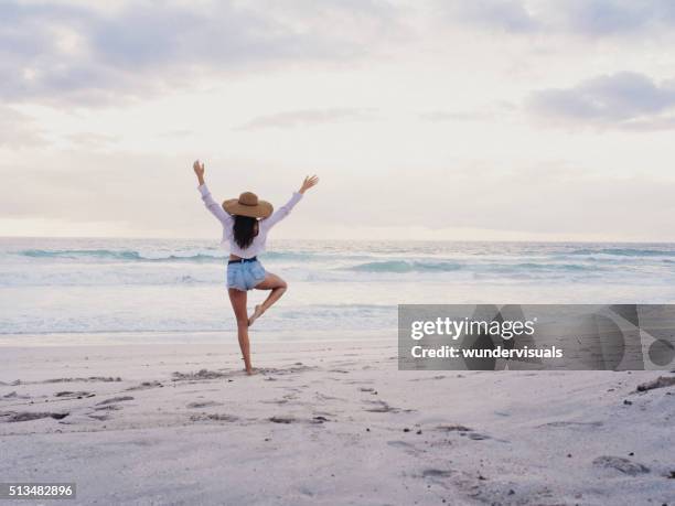 hipster girl practicing yoga pose on beach - girl beach sunset bildbanksfoton och bilder