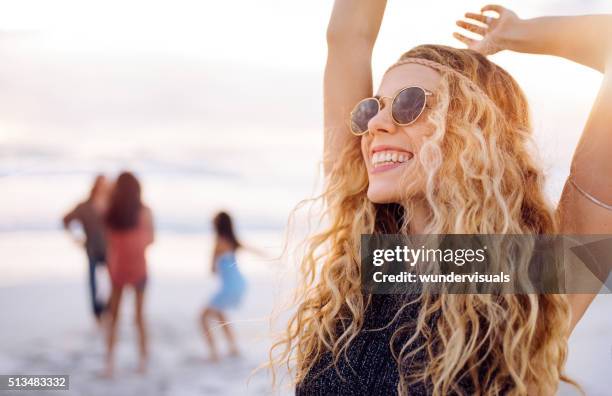 boho girl dancing on beach with friends at seaside - summer beach girl party stockfoto's en -beelden