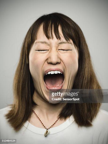 portrait of a young japanese woman screaming. - girl open mouth bildbanksfoton och bilder