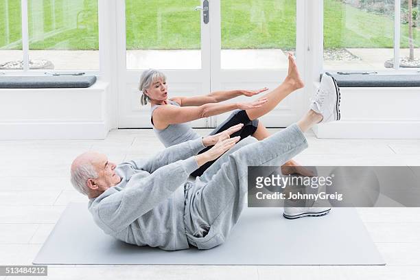 alter mann kopieren weibliche die fitness- trainer dehnung beine - agilität stock-fotos und bilder