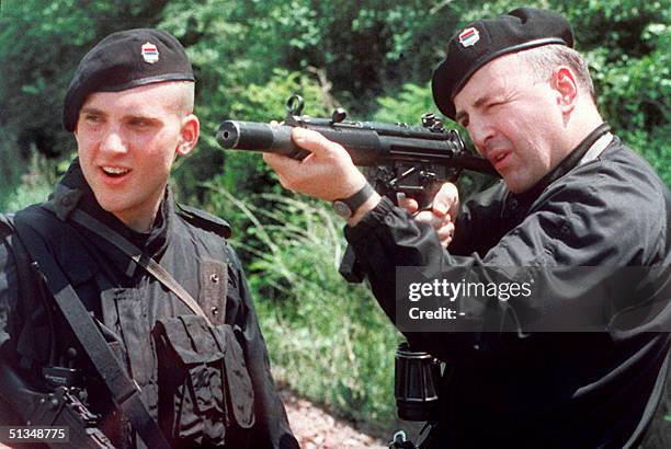 Zeljko "Arkan" Raznatovic , commander of the Serbian volunteery units, and his son MIhailo, check their weapons before heading for a patrol on the...