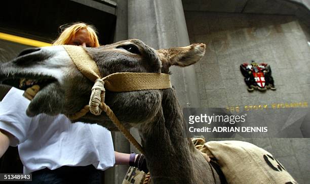 An Oxfam campaigner accompanied by a donkey outside the London Stock Exchange to protest unfair practices of giant multinational coffee companies 18...