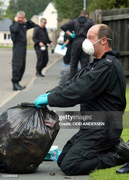 Police officers search through domestic waste looking for clues to the whereabouts of Holly Wells and Jessica Chapman in the village of Soham 08...