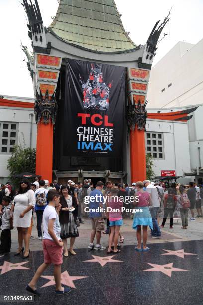 In front of the TCL Chinese Theater , people walk on the Hollywood Walk of Fame and the celebrity hand- and footprints , Los Angeles, California,...