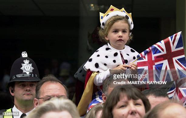Young "Queen" gets a view from the top as the parade for Queen Elizabeth II's Golden Jubilee celebrations passes by 03 June 2002, in Windsor.