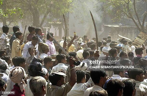 Hindu mob waves swords at an opposing Muslim mob during street battles in Bapunagr 01 March 2002 in Ahmedabad. Escalating Hindu and Muslim violence...