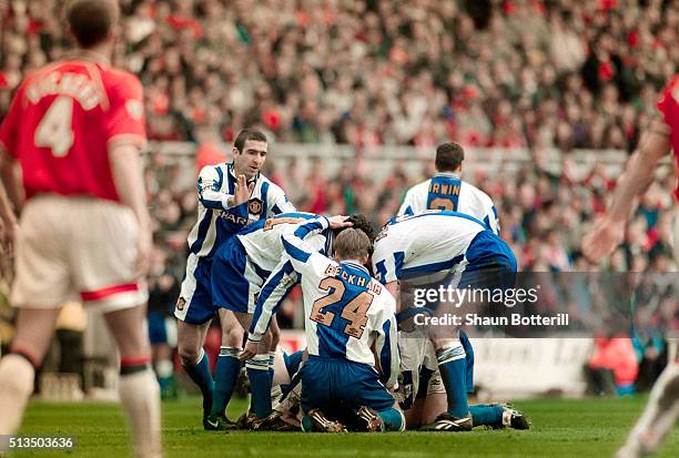 Manchester United player Eric Cantona joins in the celebrations with team mates after David May had scored the first goal in a 3-0 win to seal the...