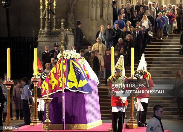 People file past the coffin of Queen Elizabeth The Queen Mother, covered with her personal standard and guarded by Life Guards 08 April 2002, in...