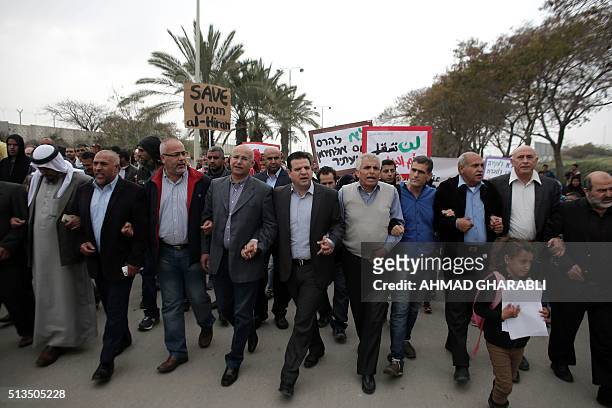 The head of Israel's Arab parliamentary bloc Ayman Odeh and Bedouin men take part in a protest against a plan to uproot the Umm Al-Hiran village,...