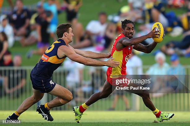 Jarrod Garlett of the Suns attempts to break clear of Jamie Cripps of the Eagles during the 2016 AFL NAB Challenge match between the West Coast...