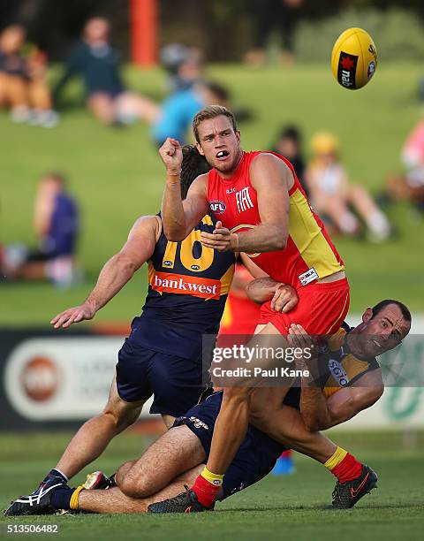 Sam Day of the Suns gets his handball away while being tackled by Shannon Hurn of the Eagles during the 2016 AFL NAB Challenge match between the West...
