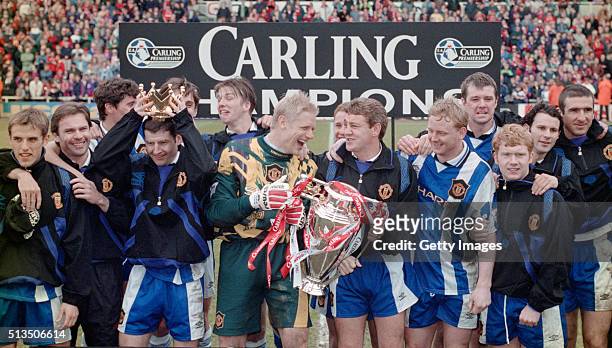 Manchester United captain Steve Bruce and goalkeeper Peter Schmeichel celebrate with team mates and the premiership trophy after winning the 1995/96...