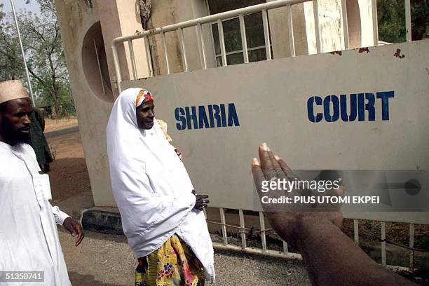 Safiya Husseini, in company of her brother Sanni, arrives at the Sokoto State Sharia Court of Appeal, 18 March, 2002 to appeal against the judgement...