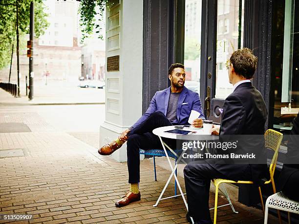 businessmen meeting at outdoor table of urban cafe - cafe table chair outside ストックフォトと画像