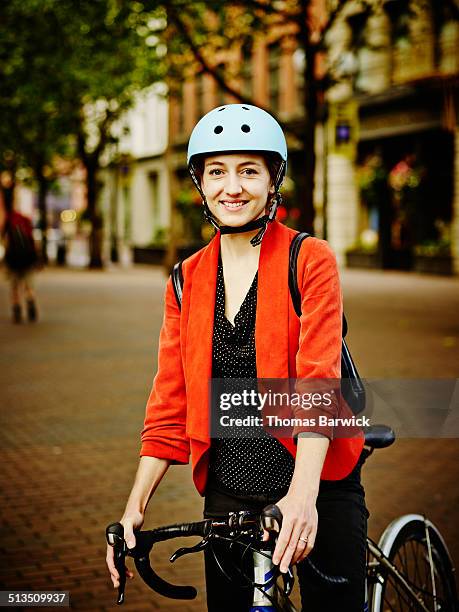 smiling businesswoman with bike on sidewalk - cycling helmet stock pictures, royalty-free photos & images