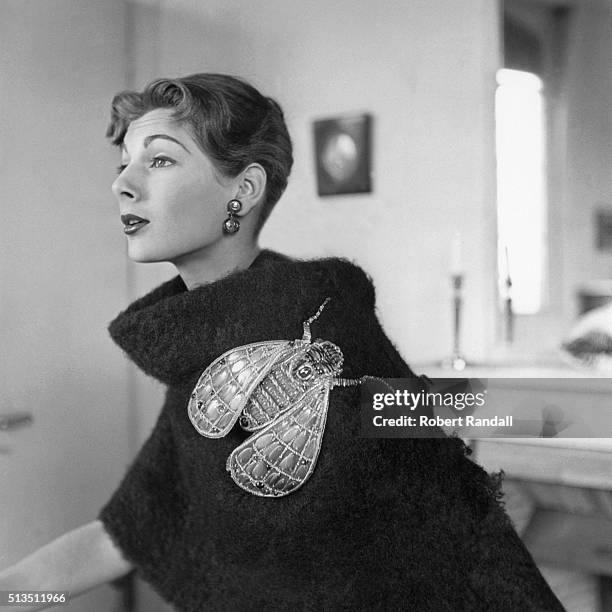 Fiona modeling black boucle shetland stole with oversized insect pin, both by Schiaparelli.