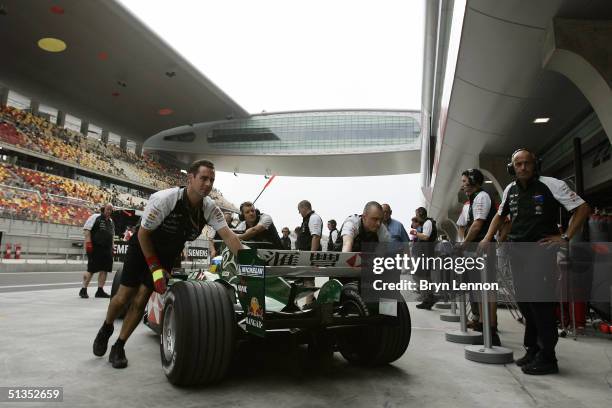 Jaguar mechanics push Christian Klien of Austria back into the pit garage during practice for the Formula One Chinese Grand Prix at Shanghai...