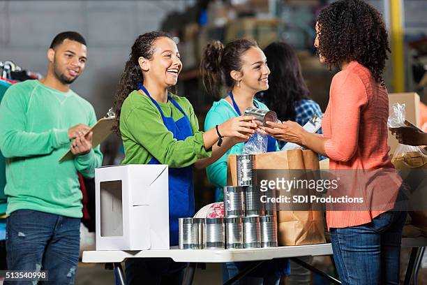 team of volunteers receive donated items - food donation stock pictures, royalty-free photos & images
