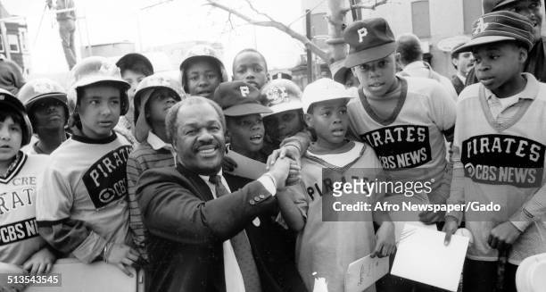 Former District of Columbia mayor Marion Barry and members of the Pittsburgh Pirates little league baseball team shaking hands, 1990.