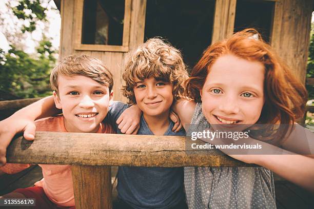 kinder in einem baumhaus lächelnd zusammen freunde - tree house stock-fotos und bilder