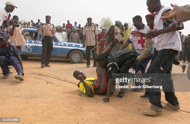 The second place winner in a bicycle race is accidentally trampled by police as he crosses the finish line during the Argungu Fishing Festival on...