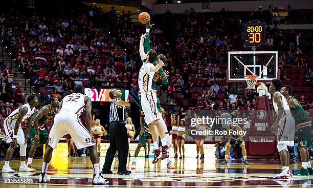 Boris Bojanovsky of the Florida State Seminoles and Tonye Jekiri of the Miami Hurricanes tip-off to start the game at the Donald L. Tucker Center on...