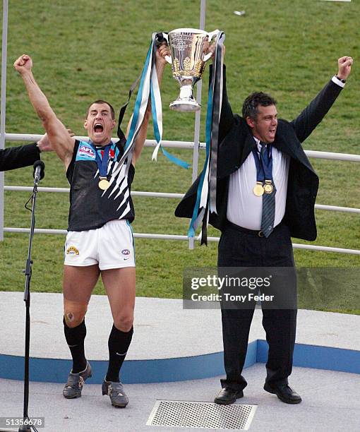 Warren Tredrea and coach Mark Williams celebrate with the AFL trophy after defeating the Brisbane Lions in the AFL Grand Final between the Port...